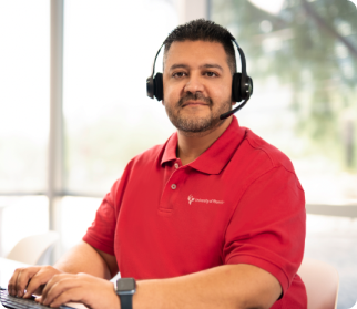 Smiling Tribal Operations Specialist with headset and fingers poised over computer keyboard