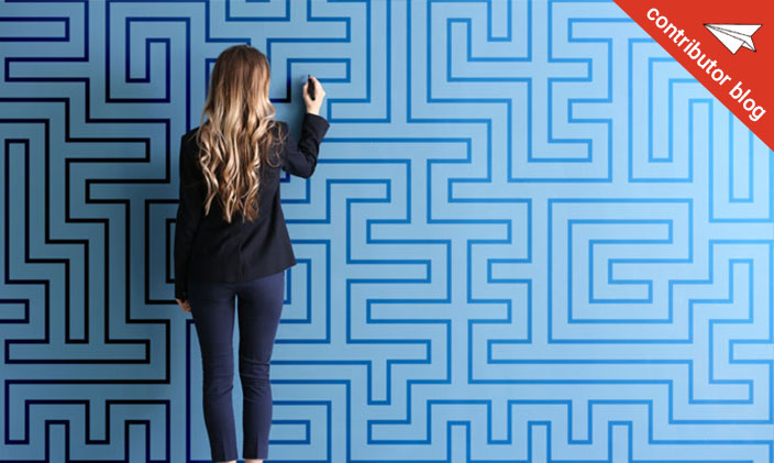 A woman attempting a maze on a wall