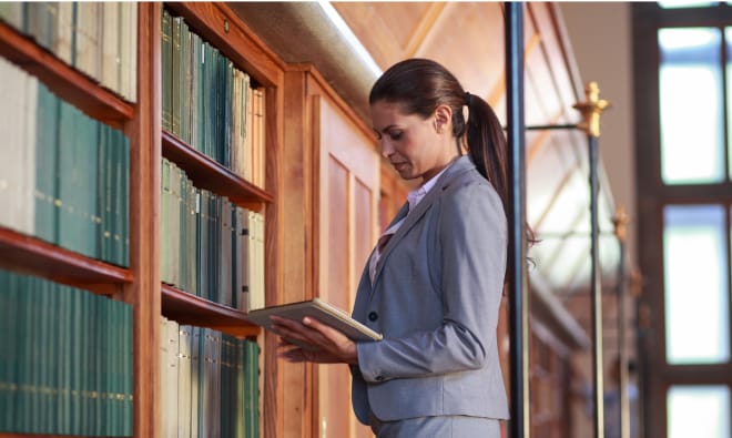 Woman working on a tablet in a library