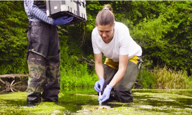 Woman taking a sample from a body of water