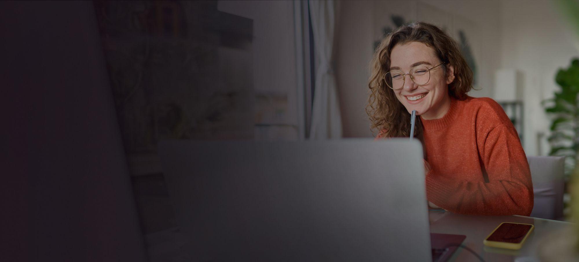 https://strapi.phoenix.eduwoman smiling and working on her laptop